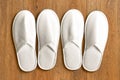 Top view two pairs white slippers in the hotel on wooden floor