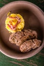 Top view on two portions of pork tenderloin on clay plate and potatoes