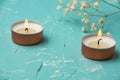 Top view of two scented white candles and copper white flowers on blue table, with selective focus, horizontal Royalty Free Stock Photo