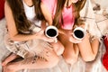 Top view of two sexy sisters drinking coffee in bed