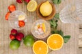 Top view of two tall glasses with water ice and strawberry. Slices fresh fruits on the table outdoor. Lime lemon and orange. Food Royalty Free Stock Photo