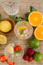 Top view of two tall glasses with water ice and strawberry. Slices fresh fruits on the table outdoor. Lime lemon and orange. Food Royalty Free Stock Photo