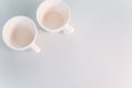 Top view of two white coffee cups on a white surface Royalty Free Stock Photo