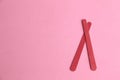 Top view of two wooden nail filers on a pink background