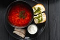 Top view of Ukrainian borscht red soup with garlic buns close-up in a bowl on the black wooden background Royalty Free Stock Photo
