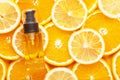 Top view of unbranded glass container with oil for hair. Transparent bottle with dispenser. Juicy slices of orange and lemon on