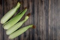 top view of uncooked corns on left side and wooden background with copy space