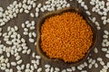 Uncooked,Dry Red Lentils Wooden Bowl on wooden surface with white beans. Royalty Free Stock Photo