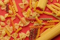 Top view of uncooked italian pasta isolated on orange. Different types of pasta, macro view Royalty Free Stock Photo