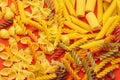 Top view of uncooked italian pasta isolated on orange. Different types of pasta, macro view Royalty Free Stock Photo