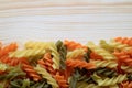 Top view of uncooked three-color spiral shaped pasta or Fusilli on wooden table Royalty Free Stock Photo