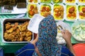 Unidentified vendor preparing Yellow Rice package at the food stall in Kota Kinabalu city food market