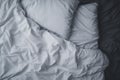 Top view of an unmade white bed with a crumpled sheet, blanket and pillows Royalty Free Stock Photo