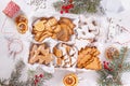 Top view of unpacked christmas present with sweets on a white textured surface framed by fir branches