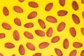 Top view of unshelled almond nuts kernels. Flat lay with food composition on yellow background.