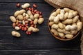 top view unshelled peanuts in a bowl with peeled on a black wooden table Royalty Free Stock Photo