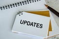 Top view of Updates text on white notepad. Business update concept. Royalty Free Stock Photo