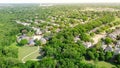 Top view upscale residential area with lush green trees, trail system, water tower in background at Flower Mound, Texas