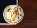 Top view of vanilla cupcake and caramel is topping and blackboard is a background on wooden table.