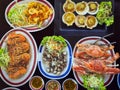 Top view of variety Seafood party table with scallop, cockle, crab, clams, shrimps, crayfish on black background. Seafood platter