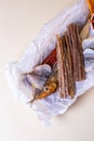 Top view a variety of smoked fish on a wooden board with a bowl of red pepper flakes. assorted fish