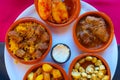 Top view of variety of tapas on small clay plates