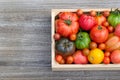 Top view of variety of tomatoes in the wooden crate on the table Royalty Free Stock Photo