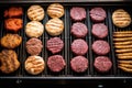 top view of various burgers cooking on a large grill