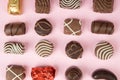 Top view of various chocolate pralines on pink background. Collection chocolates candy. Assorted chocolates on pink Royalty Free Stock Photo