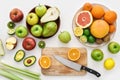 Top view of various colorful fresh summer fruits, Sliced fruits and a knife on cutting board isolated over white Royalty Free Stock Photo