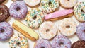 Top view of various delicious sweets, colourful round glazed donuts with sprinkles and eclairs Royalty Free Stock Photo