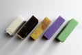 top view of various handcrafted soap with different ingredients in row on white surface. Royalty Free Stock Photo