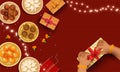 Top View Of Various Indian Sweet With Gift Boxes, Firecracker, Lighting Garland And Female Hands Opening Gift Box On Red Stripe