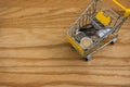 Top view of various money coins Baht in yellow mini shopping cart or supermarket trolley. Royalty Free Stock Photo