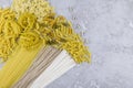 Top view of various types of dry pasta and noodles on a grey background. letters - paste Royalty Free Stock Photo