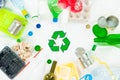 Top view of various types of trash surrounding recycle sign