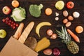 Top view of vegetables and fruits with bread in shopping bag on wooden table Royalty Free Stock Photo