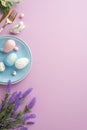 Top view vertical photo of blue plate with easter eggs cutlery ceramic rabbit and bunch of lavender flowers Royalty Free Stock Photo