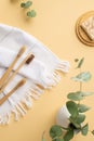 Top view vertical photo of vase with eucalyptus white cotton towel toothbrushes and soap on bamboo stand on isolated pastel beige Royalty Free Stock Photo