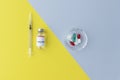 top view of vial with vaccine and syringe on yellow background, plate with pills on grey background, comparison of two methods of