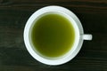 Top View of Vibrant Green Color Hot Matcha Green Tea on Dark Brown Wooden Table