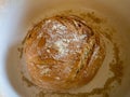 Top view view of a round loaf of freshly baked in a white bowl