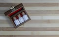 Top view of vintage Bottles of homeopathic pills in a retro styled opened wooden box on wood background