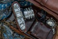 Top view of a vintage photo camera and a brown leather bag with scarf, glasses and pocket watch on sack cloth background Royalty Free Stock Photo