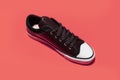 Top view of vintage sneaker shoe on coral pink background.