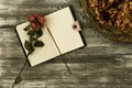 Top view of vintage tray with petals of dried rose flowers and a diary or notebook and dried rose flower on a gray wooden table. F Royalty Free Stock Photo