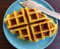 Top view of waffle topped with honey sauce on blue plate at cafe. Flat lay of Sweet bakery on dish