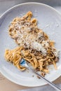 Top view of Wagyu Ragu with Tagliatelle pasta topping with cheddar cheese. Rolled spaghetti with fork Royalty Free Stock Photo