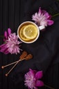 Top view of warm cup of tea, brown sugar sticks and pink flowers Royalty Free Stock Photo