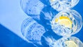 Top view of Water in the glass with lemon slices against blue background, sunlight and deep shadow, summer lemonade, Ice drink, Royalty Free Stock Photo